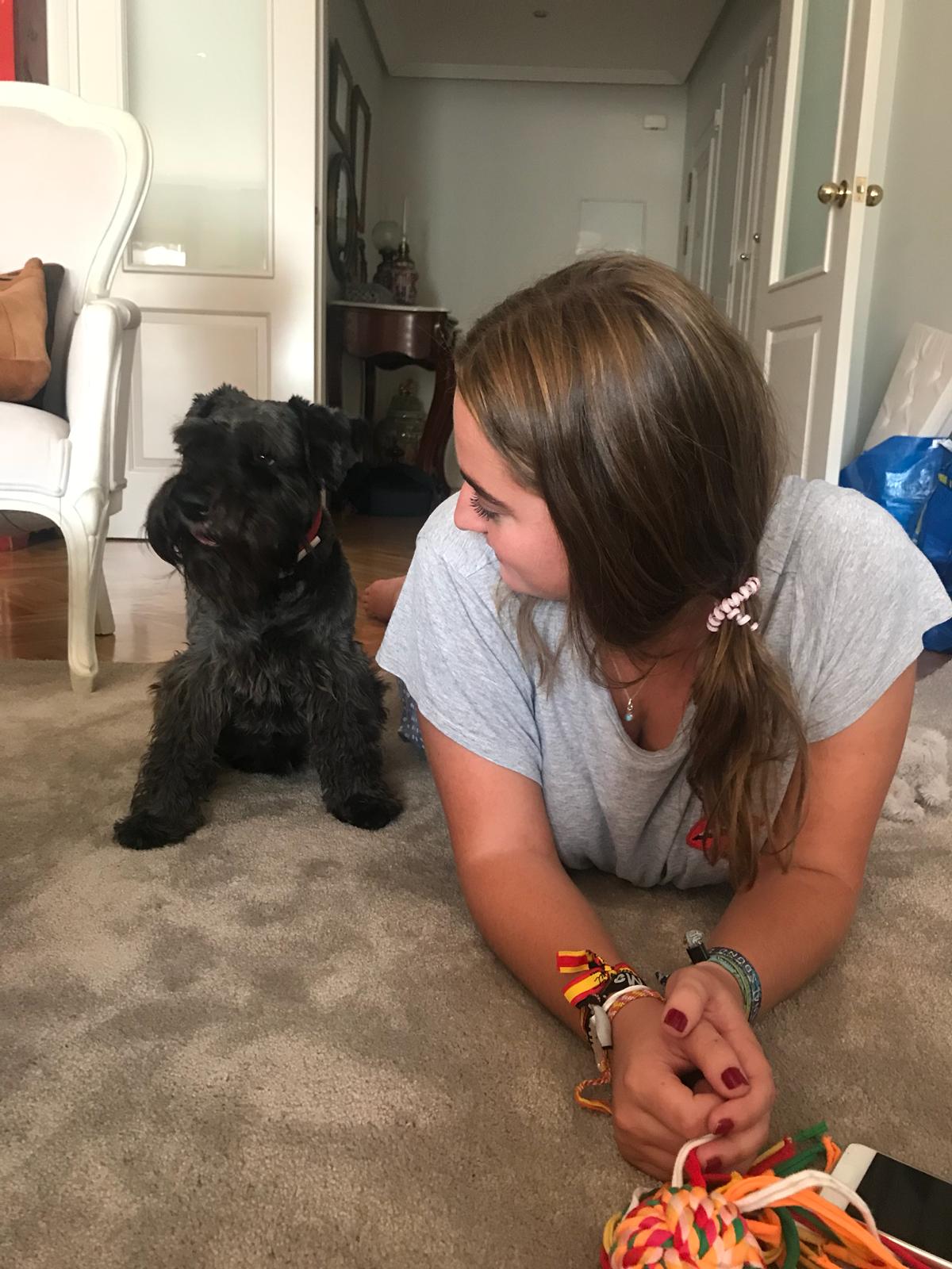 Claudia y su perro Mateo tumbados en la alfombra de la casa